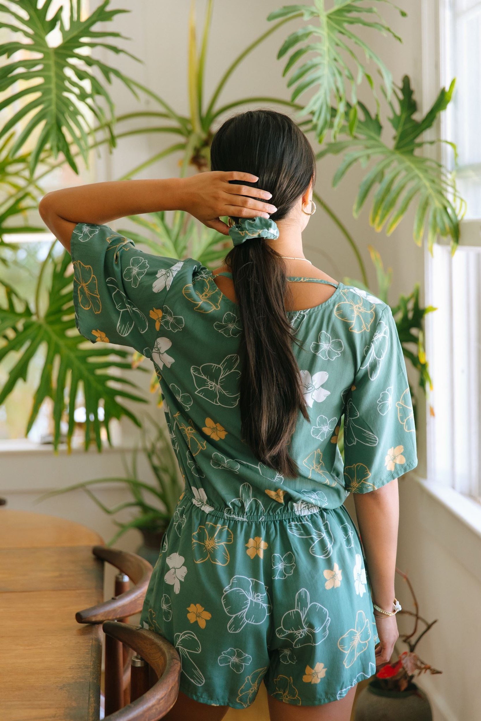 woman wearing lush green scrunchie with puakenikeni print