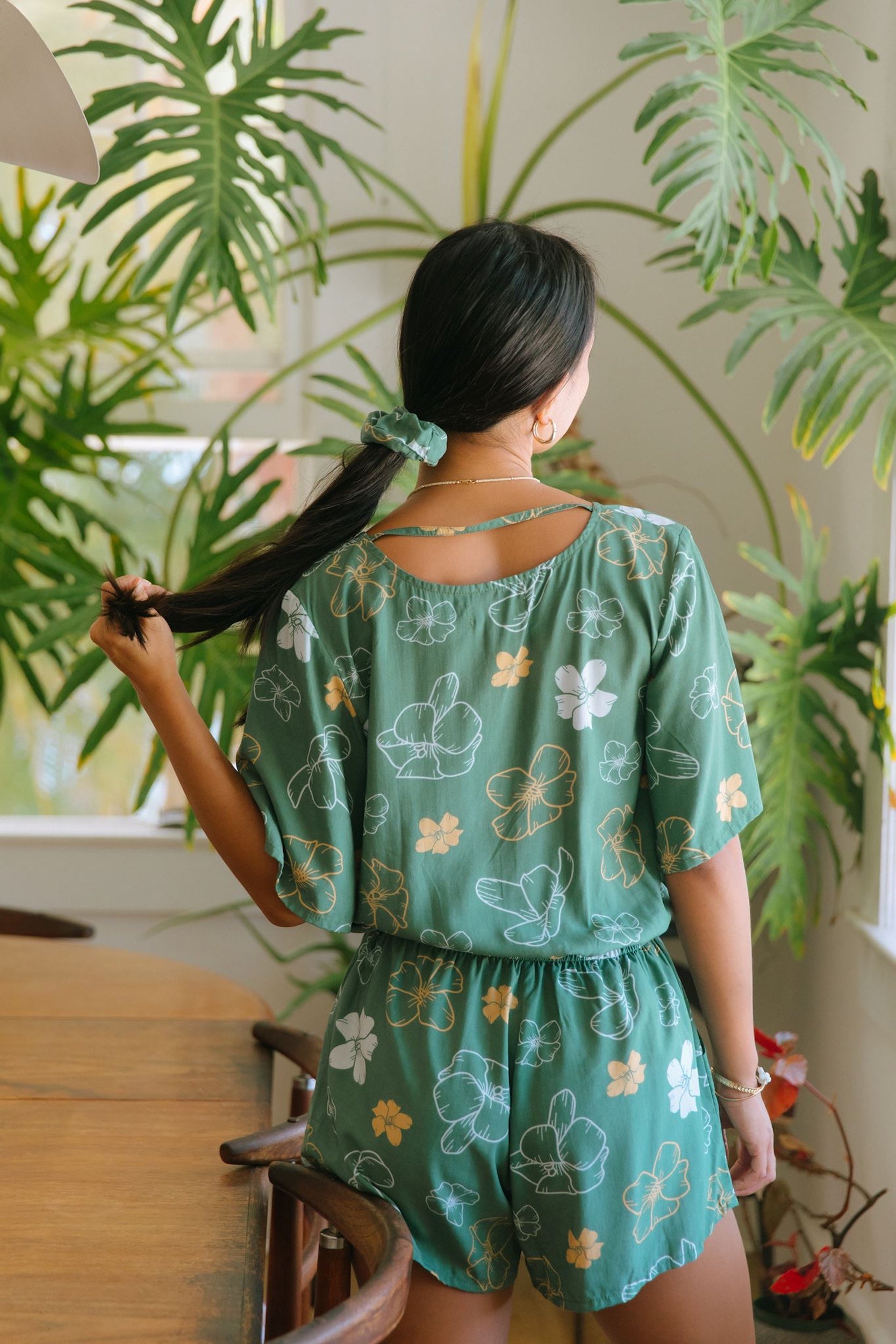 woman wearing lush green scrunchie with puakenikeni print
