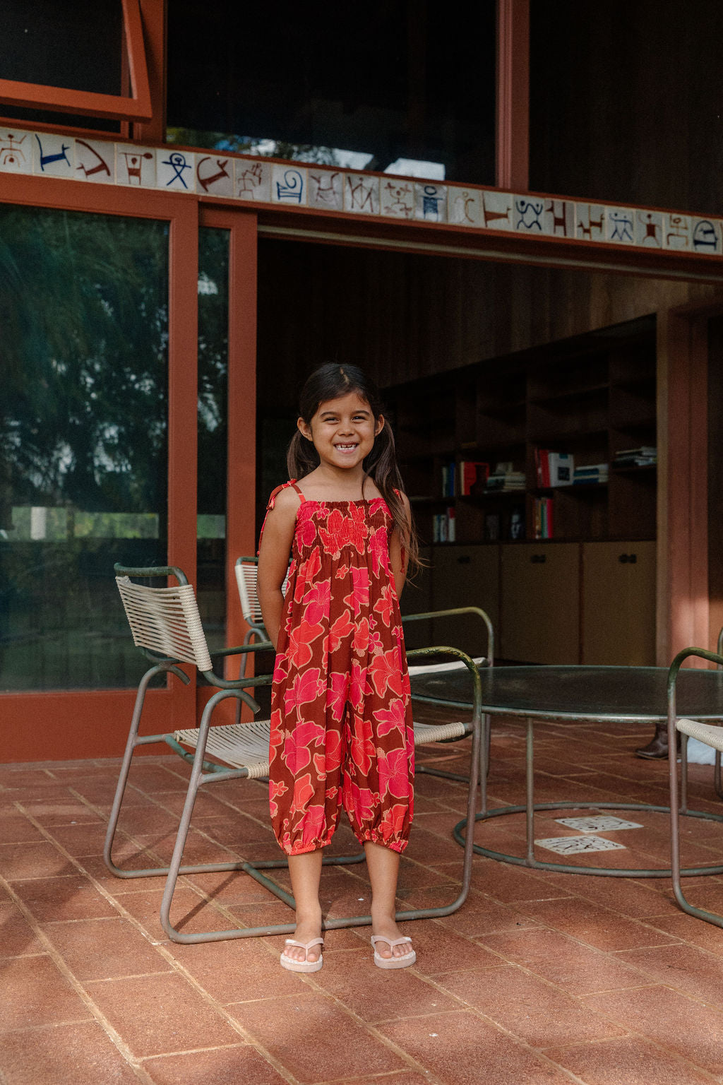 little girl wearing jumpsuit with retro pink pua pattern