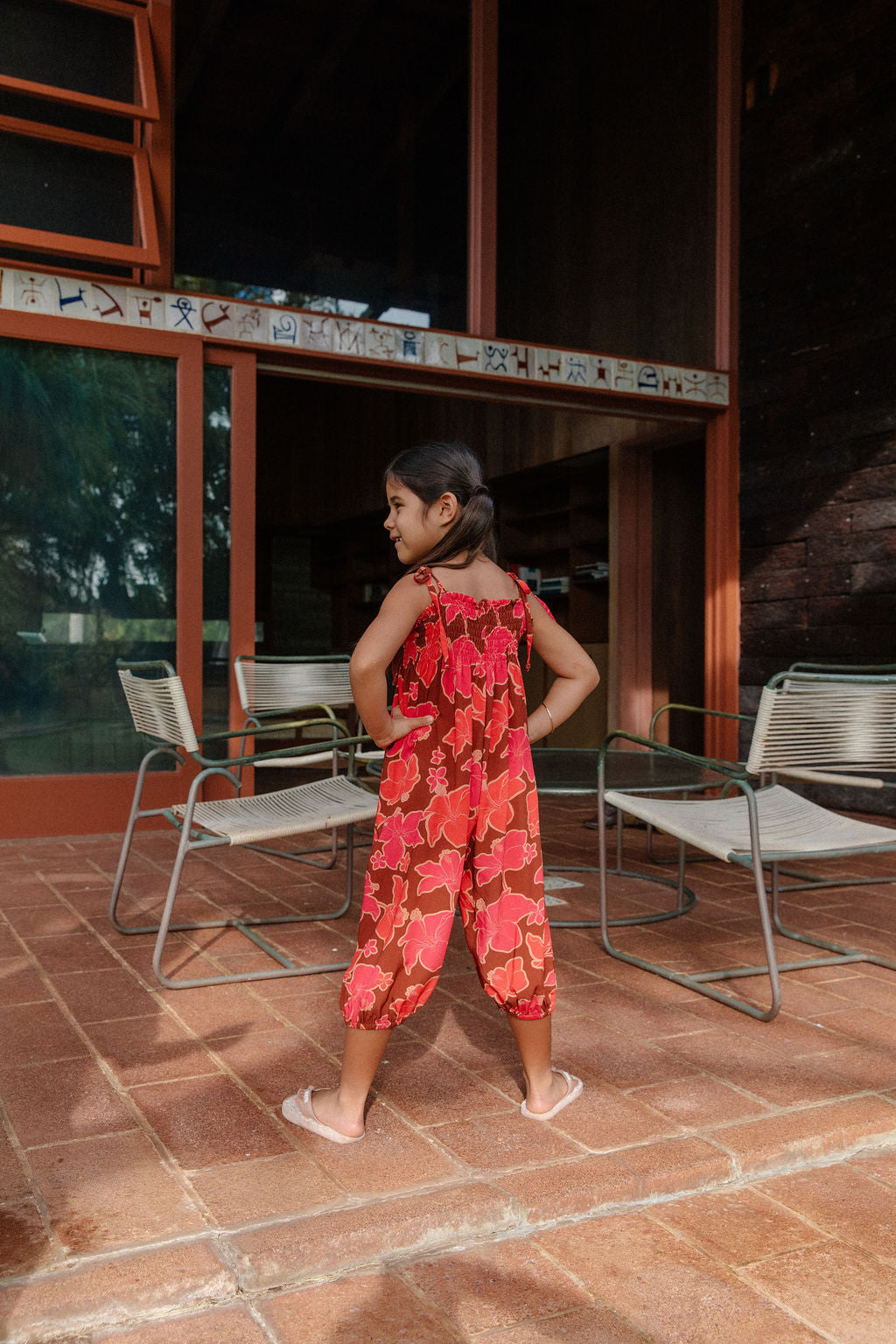 little girl wearing jumpsuit with retro pink pua pattern