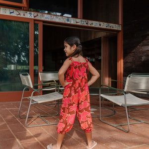 little girl wearing jumpsuit with retro pink pua pattern