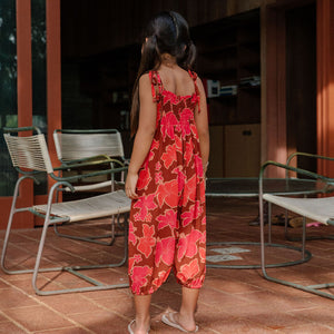 little girl wearing jumpsuit with retro pink pua pattern