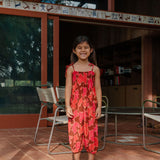 little girl wearing jumpsuit with retro pink pua pattern