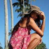 women with brown hair wearing a mini dress with shells and pua print in pink