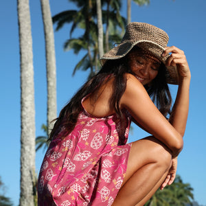 women with brown hair wearing a mini dress with shells and pua print in pink