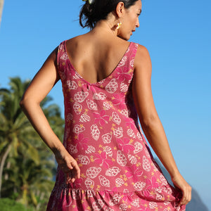 women with brown hair wearing a mini dress with shells and pua print in pink