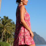women with brown hair wearing a mini dress with shells and pua print in pink