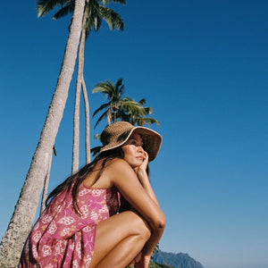 women with brown hair wearing a mini dress with shells and pua print in pink