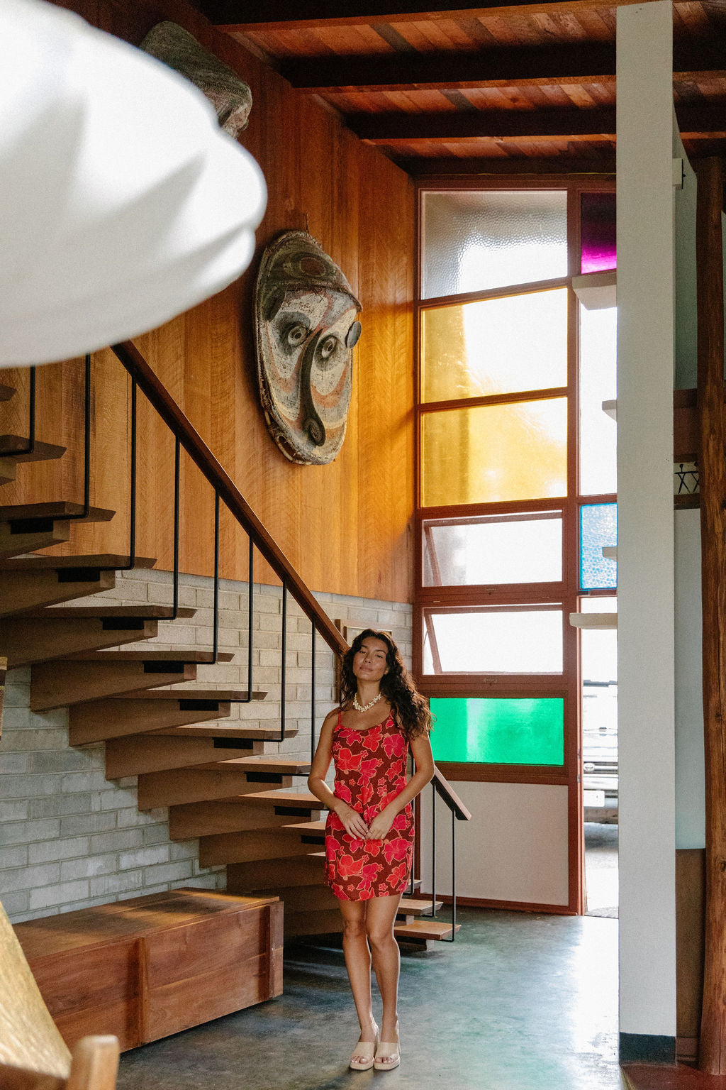 woman with brown hair wearing a spaghetti strap mini slip dress with retro pink pua print