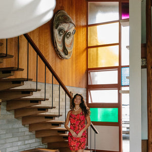 woman with brown hair wearing a spaghetti strap mini slip dress with retro pink pua print