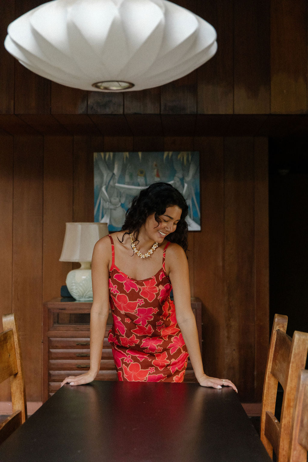 woman with brown hair wearing a spaghetti strap mini slip dress with retro pink pua print