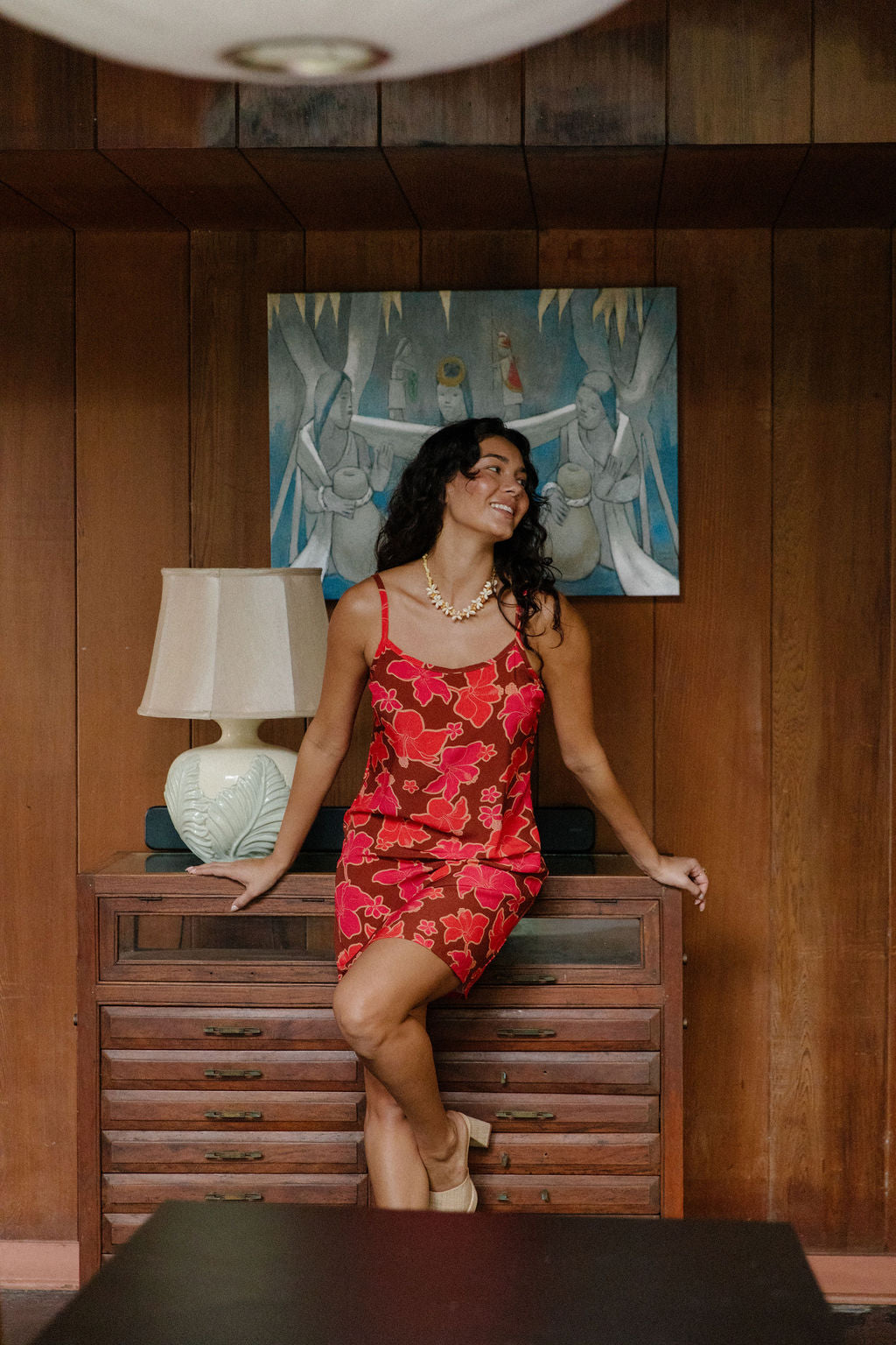 woman with brown hair wearing a spaghetti strap mini slip dress with retro pink pua print