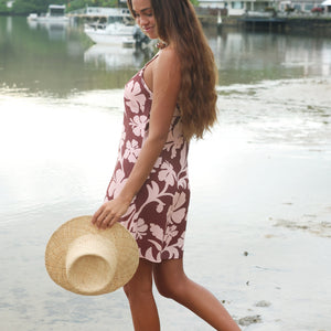 Woman with brown hair wearing a simple slip dress with scoop neck in blush and brown hibiscus print