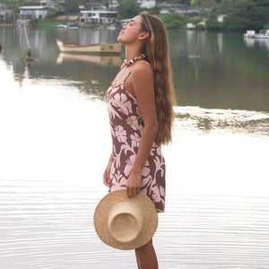 Woman with brown hair wearing a simple slip dress with scoop neck in blush and brown hibiscus print