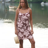 Woman with brown hair wearing a simple slip dress with scoop neck in blush and brown hibiscus print