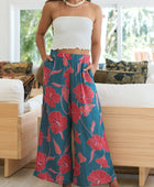 Woman wearing loose blue pants with large pink floral print.