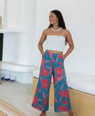 Woman wearing loose blue pants with large pink floral print.