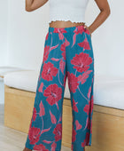 Woman wearing loose blue pants with large pink floral print.