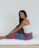 Woman wearing loose blue pants with large pink floral print.