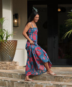 Woman wearing blue sleeveless maxi dress with large pink and red floral print.