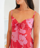 Woman wearing red sleeveless mini dress with large pink flowers print.