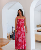 Woman wearing red sleeveless maxi dress with large pink floral print.