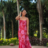 Woman wearing red sleeveless maxi dress with large pink floral print.