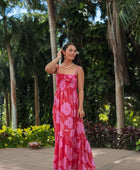 Woman wearing red sleeveless maxi dress with large pink floral print.