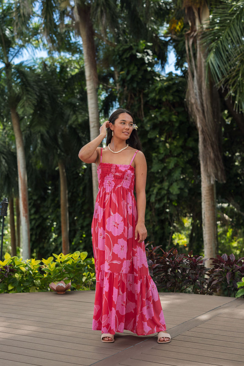 Woman wearing red sleeveless maxi dress with large pink floral print.