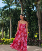 Woman wearing red sleeveless maxi dress with large pink floral print.