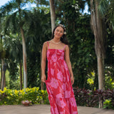 Woman wearing red sleeveless maxi dress with large pink floral print.