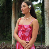 Woman wearing red sleeveless maxi dress with large pink floral print.