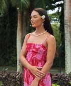 Woman wearing red sleeveless maxi dress with large pink floral print.