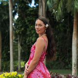 Woman wearing red sleeveless maxi dress with large pink floral print.