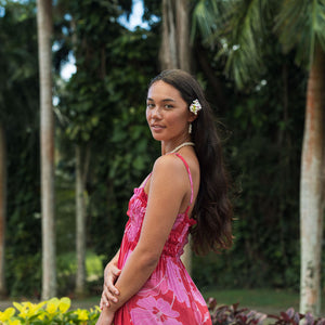Woman wearing red sleeveless maxi dress with large pink floral print.