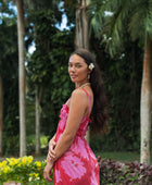 Woman wearing red sleeveless maxi dress with large pink floral print.