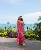 Woman wearing red sleeveless maxi dress with large pink floral print.