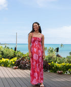 Woman wearing red sleeveless maxi dress with large pink floral print.