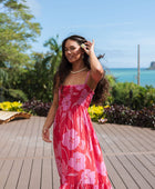 Woman wearing red sleeveless maxi dress with large pink floral print.