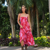 Woman wearing red sleeveless maxi dress with large pink floral print.