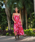 Woman wearing red sleeveless maxi dress with large pink floral print.