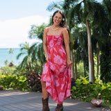 Woman wearing red sleeveless maxi dress with large pink floral print.