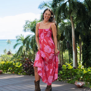 Woman wearing red sleeveless maxi dress with large pink floral print.