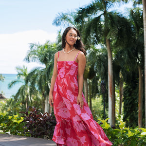 Woman wearing red sleeveless maxi dress with large pink floral print.
