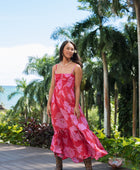 Woman wearing red sleeveless maxi dress with large pink floral print.