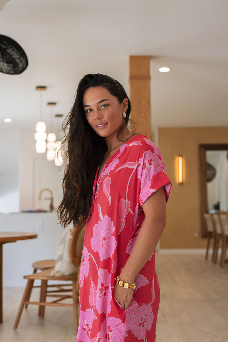 Woman wearing red short shirtdress with large pink floral print.