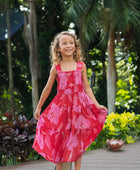 Girl wearing long red sleeveless dress with large pink floral print.