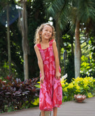 Girl wearing long red sleeveless dress with large pink floral print.