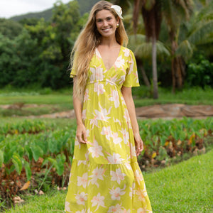 woman wearing a bright green v neck maxi dress with flutter sleeves with orchid print