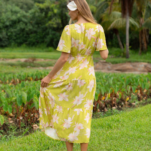 woman wearing a bright green v neck maxi dress with flutter sleeves with orchid print